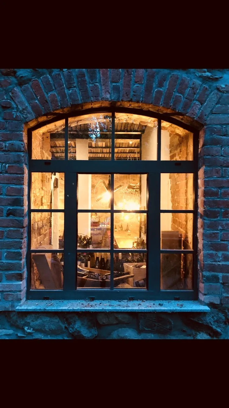 Beleuchtetes Mühlenfenster bei Abenddämmerung