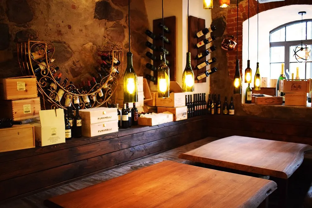 Gewölbtes Weinregal aus Schmiedeeisen vor Feldsteinwand